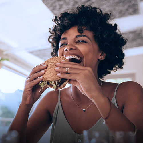 A woman eating a hamburger in a restaurant