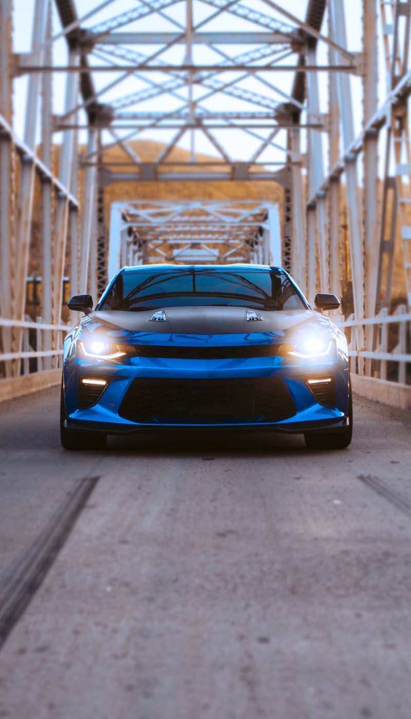 Front view of blue sports car on bridge