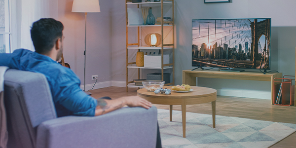 Man viewing programmatic linear tv ads on a television